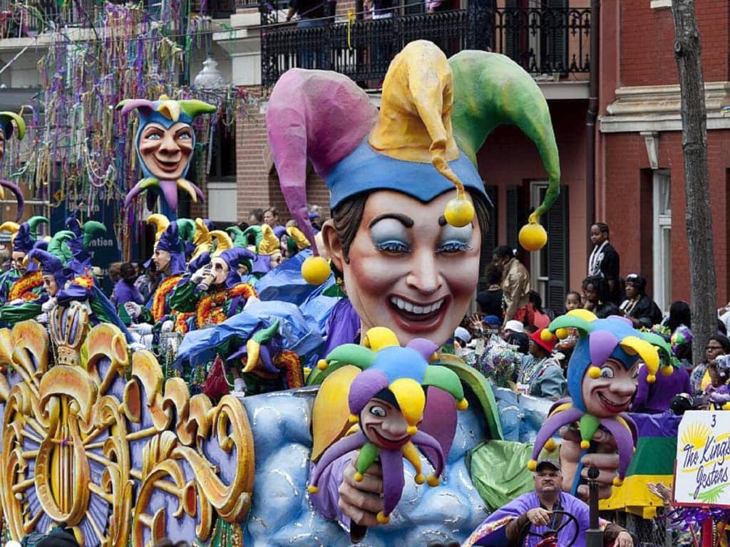 Mardi Gras parade float and performers in jester costumes